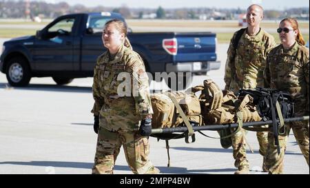 Airman Hailey Endsley, principal de la Force aérienne (à gauche), et des membres de l'escadron d'évacuation aéromédical 445th, chargent une fausse victime à bord d'un C-17 Globemaster III lors d'un exercice d'entraînement conjoint à la base aérienne Wright-Patterson, Ohio, le 9 novembre 2022. L'escadron d'évacuation aéromédicale 445th et l'équipe de transport aérien de soins critiques du Groupe médical 88th ont mené la formation, simulant un environnement de vol en direct où les aviateurs apprennent à se préparer à des défis tels que la turbulence, les changements de température et la pression de l'air, car ils s'occupent de patients gravement malades. Banque D'Images