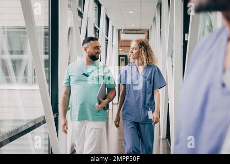 Le personnel hospitalier multiracial masculin et féminin se promenant dans le couloir Banque D'Images