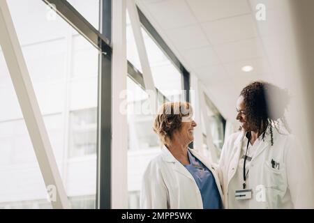 Des médecins multiraciaux heureux se regardant les uns les autres à l'hôpital Banque D'Images