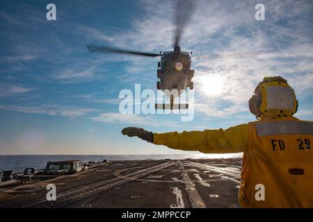 221111-N-OK195-1317 MER IONIENNE (le 11 novembre 2022) le compagnon de Boatswain de classe 3rd Tai Soldo, affecté au destroyer USS Truxtun (DDG 103) de la classe Arleigh Burke, envoie un signal à un hélicoptère MH-60R Sea Hawk, attaché à l’Escadron de frappe maritime d’hélicoptère (HSM) 46, le 11 novembre 2022. Carrier Air Wing (CVW) 7 est la composante aérienne et de grève offensive du Carrier Strike Group (CSG) 10 et du George H.W. CSG de bague. Les escadrons du CVW-7 sont le Strike Fighter Squadron (VFA) 143, le VFA-103, le VFA-86, le VFA-136, le Electronic Attack Squadron (VAQ) 140, le Carrier Airborne Early Warning Squadron (VAW) 121, Helicopte Banque D'Images
