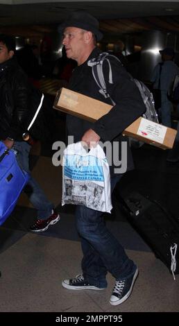 Exclusif !! L'acteur Corbin Bernsen de 54 ans et sa femme Amanda pays, actrice britannique de 49 ans, arrivent à LAX. Le couple a joyeusement posé pour des photos et bavardé avec des fans. Corbin transportait une longue boîte qui tenait des affiches de son film de la Ligue majeure II de 1994. Los Angeles, Californie. 4/19/2009. Banque D'Images