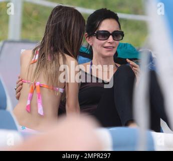 Courteney Cox, star de la ville de Cougar, et Coco, fille de 8 ans, ont été vus passer la journée à la plage en profitant du soleil. Bien que Courteney soit resté couvert d'un haut rayé à manches longues et de leggings noirs, Coco portait un bikini rose. Miami Beach, Floride. 18th novembre 2012. Banque D'Images