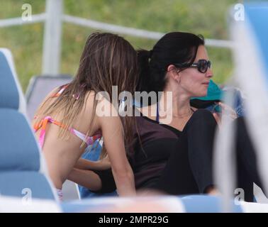 Courteney Cox, star de la ville de Cougar, et Coco, fille de 8 ans, ont été vus passer la journée à la plage en profitant du soleil. Bien que Courteney soit resté couvert d'un haut rayé à manches longues et de leggings noirs, Coco portait un bikini rose. Miami Beach, Floride. 18th novembre 2012. Banque D'Images