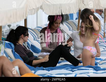 Courteney Cox, star de la ville de Cougar, et Coco, fille de 8 ans, ont été vus passer la journée à la plage en profitant du soleil. Bien que Courteney soit resté couvert d'un haut rayé à manches longues et de leggings noirs, Coco portait un bikini rose. Miami Beach, Floride. 18th novembre 2012. Banque D'Images