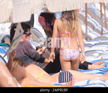 Courteney Cox, star de la ville de Cougar, et Coco, fille de 8 ans, ont été vus passer la journée à la plage en profitant du soleil. Bien que Courteney soit resté couvert d'un haut rayé à manches longues et de leggings noirs, Coco portait un bikini rose. Miami Beach, Floride. 18th novembre 2012. Banque D'Images