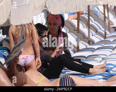 Courteney Cox, star de la ville de Cougar, et Coco, fille de 8 ans, ont été vus passer la journée à la plage en profitant du soleil. Bien que Courteney soit resté couvert d'un haut rayé à manches longues et de leggings noirs, Coco portait un bikini rose. Miami Beach, Floride. 18th novembre 2012. Banque D'Images