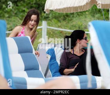 Courteney Cox, star de la ville de Cougar, et Coco, fille de 8 ans, ont été vus passer la journée à la plage en profitant du soleil. Bien que Courteney soit resté couvert d'un haut rayé à manches longues et de leggings noirs, Coco portait un bikini rose. Miami Beach, Floride. 18th novembre 2012. Banque D'Images