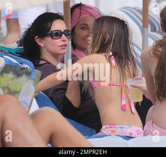 Courteney Cox, star de la ville de Cougar, et Coco, fille de 8 ans, ont été vus passer la journée à la plage en profitant du soleil. Bien que Courteney soit resté couvert d'un haut rayé à manches longues et de leggings noirs, Coco portait un bikini rose. Miami Beach, Floride. 18th novembre 2012. Banque D'Images