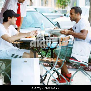 EXCLUSIF !! Craig David, chanteur britannique de R&B, est présent pour déjeuner dans un restaurant extérieur situé sur Lincoln Road avec un ami. Craig, dont le cinquième album studio signé Sealed livré est sorti en mars, s'est aidé à une assiette de nourriture partagée et s'est assis avec un sac Nike unique et sneaker, placé au-dessus de son épaule. Miami Beach, Floride. 08/29/10. Banque D'Images