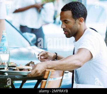 EXCLUSIF !! Craig David, chanteur britannique de R&B, est présent pour déjeuner dans un restaurant extérieur situé sur Lincoln Road avec un ami. Craig, dont le cinquième album studio signé Sealed livré est sorti en mars, s'est aidé à une assiette de nourriture partagée et s'est assis avec un sac Nike unique et sneaker, placé au-dessus de son épaule. Miami Beach, Floride. 08/29/10. Banque D'Images