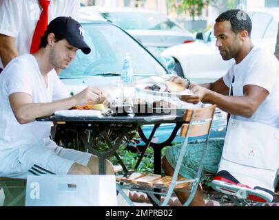 EXCLUSIF !! Craig David, chanteur britannique de R&B, est présent pour déjeuner dans un restaurant extérieur situé sur Lincoln Road avec un ami. Craig, dont le cinquième album studio signé Sealed livré est sorti en mars, s'est aidé à une assiette de nourriture partagée et s'est assis avec un sac Nike unique et sneaker, placé au-dessus de son épaule. Miami Beach, Floride. 08/29/10. Banque D'Images