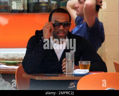 EXCLUSIF !! Le chanteur britannique Craig David roule sur Lincoln Road à South Beach, s'arrêtant devant un café local pour vérifier son téléphone portable. Vêtu d'un sweat à capuche, d'un short et de baskets montantes noirs, David s'est également arrêté pour boire un verre avec un ami dans un bar le long de la célèbre galerie marchande piétonne. Craig David sortirait un nouvel album plus tard cette année. Son album le plus récent, « Sed Sealed livré », a frappé Stores en mars 2010 et est entré dans le classement des albums du Royaume-Uni au numéro 13. Miami Beach, Floride. 1/3/11. Banque D'Images