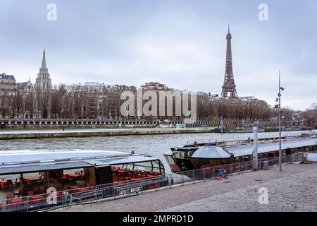 Deux bateaux mouche sont amarrés le long de la Seine avec la Tour Eiffel en arrière-plan. Banque D'Images