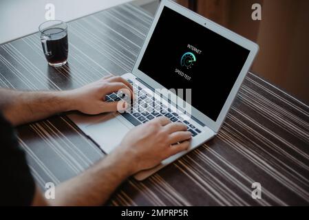 Homme vérifiant la vitesse de connexion Internet sur l'ordinateur portable Banque D'Images