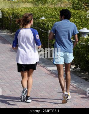 Jamel Debbouze et Melissa Theuriau vont faire un jogging. Les jambes de Debbouze montrent les cicatrices de son accident de voiture presque mortel en 1990. Miami, Floride. 2/27/09 Banque D'Images