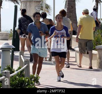 Jamel Debbouze et Melissa Theuriau vont faire un jogging. Les jambes de Debbouze montrent les cicatrices de son accident de voiture presque mortel en 1990. Miami, Floride. 2/27/09 Banque D'Images