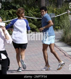 Jamel Debbouze et Melissa Theuriau vont faire un jogging. Les jambes de Debbouze montrent les cicatrices de son accident de voiture presque mortel en 1990. Miami, Floride. 2/27/09 Banque D'Images