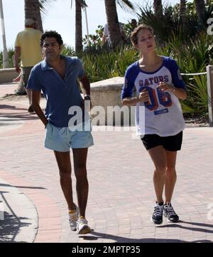 Jamel Debbouze et Melissa Theuriau vont faire un jogging. Les jambes de Debbouze montrent les cicatrices de son accident de voiture presque mortel en 1990. Miami, Floride. 2/27/09 Banque D'Images