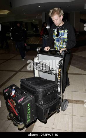 Deryck Whibley arrive à LAX après un voyage à Moscou pour les prix de la télévision Muz. Il a l'air fatigué mais pousse ses bagages vers la voiture d'attente. Los Angeles, Californie. 6/6/09. . Banque D'Images