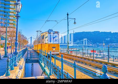BUDAPEST, HONGRIE - 2 MARS 2022 : le tramway jaune de style rétro longe le quai du Danube, le lieu touristique populaire, sur 2 mars à Budapest Banque D'Images