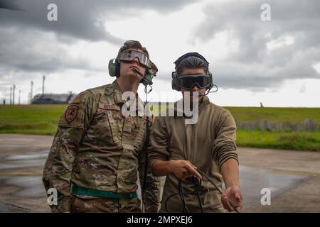 ÉTATS-UNIS Air Force Airman Nathan Waters, à gauche, et Airman 1st classe Jose Barrera-Mattzer, à droite, chefs d'équipage affectés à l'unité d'entretien des hélicoptères 33rd stand by pour lancer un HH-60G Pave Hawk à la base aérienne de Kadena, au Japon, le 22 novembre 2022. 33rd les aviateurs de l’UHE veillent à ce que les aéronefs à leur charge soient prêts à voler à un moment donné afin que l’escadron de sauvetage 33rd puisse terminer leur mission de façon sécuritaire et efficace. Banque D'Images