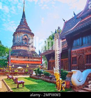 Le mur latéral de bois de teakwood de Viharn de Wat Lok Moli et son ancienne brique Chedi au premier plan, Chiang Mai, Thaïlande Banque D'Images