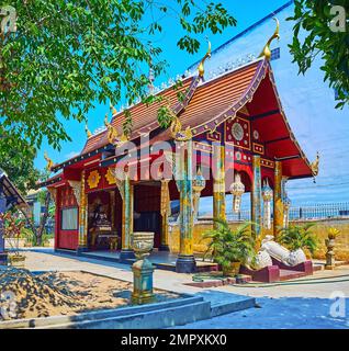 Le petit sanctuaire d'un petit temple Wat Hor Pra, décoré de colonnes dorées, toit en forme de pyathe, lanternes Lanna et image de Bouddha à l'intérieur, Chiang Mai, Thaïlande Banque D'Images