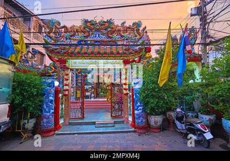 Porte de Pung Thao Kong ornée de paifang avec des plantes vertes luxuriantes en premier plan, Chiang Mai, Thaïlande Banque D'Images