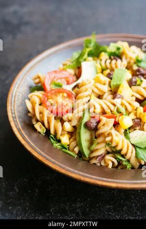 Salade de pâtes mexicaines végétaliennes maison avec avocat, haricots et maïs. Banque D'Images