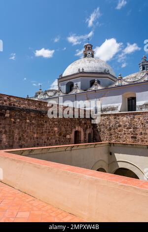 Dôme de l'église de Saint-Domingue de Guzman à Ocotlan de Morelos, Oaxaca, Mexique avec le sommet du monastère en face. Banque D'Images