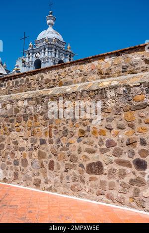 Clocher de l'église Saint-Domingue de Guzman à Ocotlan de Morelos, Oaxaca, Mexique avec le sommet du monastère en face. Banque D'Images