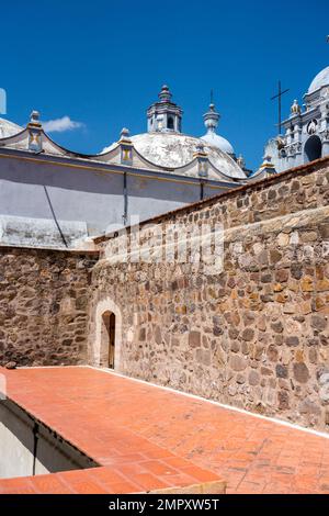 Dôme de l'église de Saint-Domingue de Guzman à Ocotlan de Morelos, Oaxaca, Mexique avec le sommet du monastère en face. Banque D'Images