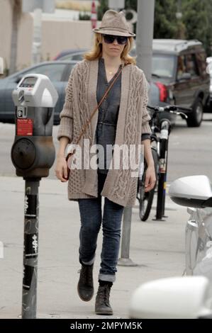 L'actrice Elizabeth Banks a l'air terreuse dans un fedora, pull en maille torsadée, haut gris et jeans jumelés avec des bottes noires et un petit sac à main marron comme elle quitte un magasin de sandwich. L'étoile « un sur un bord » sourit alors qu'elle se promenait avec une tasse à emporter et discutait avec un ami. Los Angeles, Californie. 7th février 2012. Banque D'Images