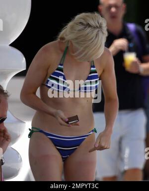 Ellie Goulding, chanteuse britannique à la peau équitable, semble souffrir d'un grave coup de soleil. Le topper à motif carte blonde a montré ses lignes de bronzage dans un bikini rayé alors qu'elle a détendu le bord de la piscine à son hôtel. Goulding est actuellement en ville pour aider Richard Branson à célébrer 25 ans de Virgin Atlantic reliant Miami à Londres. Le jour précédent Goulding a pris un déversement d'un segway portant une paire de pantalons. La ligne visible de coup de soleil montrant où se termine son short. Miami, Floride. 6/17/11 Banque D'Images