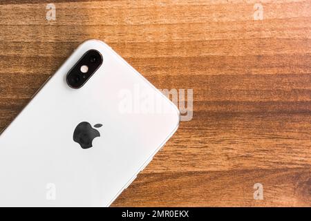 Biélorussie, région de Minsk - 17 mars 2020: IPhone mobile Apple smartphone se trouve sur un fond de table en bois. Banque D'Images