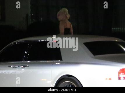 EXCLUSIF !! EXCLUSIF !! Après sa représentation au gala de l'inspiration amfAR, Lady Gaga a quitté l'événement tôt le matin et a pris un tour sur Sunset Boulevard pour manger un morceau au Burger In-N-Out local. Comme une scène d'un film, la star ressemblait à la reine Boadicea à monter son char blanc immaculé alors qu'elle se levait à travers le toit ouvrant de son Rolls Royce blanc mouvant. Tout en attendant son en-cas de fin de soirée, Lady Gaga s'est assise sur le siège passager avant en percutant les mains sur le tableau de bord pendant que sa garde du corps est allée au restaurant Junkfood pour récupérer sa commande. Banque D'Images