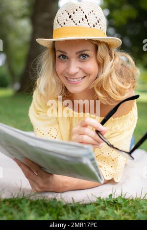 femme dans le parc lisant le journal Banque D'Images