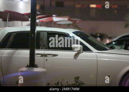 EXCLUSIF !! EXCLUSIF !! Après sa représentation au gala de l'inspiration amfAR, Lady Gaga a quitté l'événement tôt le matin et a pris un tour sur Sunset Boulevard pour manger un morceau au Burger In-N-Out local. Comme une scène d'un film, la star ressemblait à la reine Boadicea à monter son char blanc immaculé alors qu'elle se levait à travers le toit ouvrant de son Rolls Royce blanc mouvant. Tout en attendant son en-cas de fin de soirée, Lady Gaga s'est assise sur le siège passager avant en percutant les mains sur le tableau de bord pendant que sa garde du corps est allée au restaurant Junkfood pour récupérer sa commande. Banque D'Images