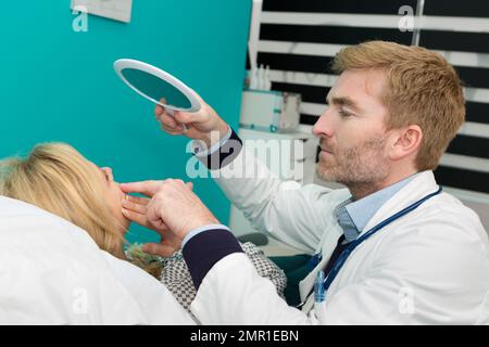 médecin vérifiant la peau du patient à l'aide d'une loupe Banque D'Images