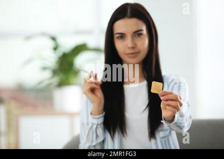 Bonne jeune femme avec timbre de nicotine et cigarette à la maison, se concentrer sur la main Banque D'Images