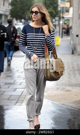 BBC radio 1 DJ Fearne Cotton prend un taxi à la maison après le travail au lieu de prendre sa promenade habituelle sur un vendredi pluvieux à Londres. Fearne, qui doit se rendre au Pérou pour une marche caritative la semaine prochaine, travaille une paire de talons aiguilles funky révélant le grand tatouage sur son pied, un chandail rayé et un pantalon gris. Londres, Royaume-Uni. 9/24/10. Banque D'Images