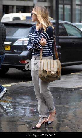 BBC radio 1 DJ Fearne Cotton prend un taxi à la maison après le travail au lieu de prendre sa promenade habituelle sur un vendredi pluvieux à Londres. Fearne, qui doit se rendre au Pérou pour une marche caritative la semaine prochaine, travaille une paire de talons aiguilles funky révélant le grand tatouage sur son pied, un chandail rayé et un pantalon gris. Londres, Royaume-Uni. 9/24/10. Banque D'Images