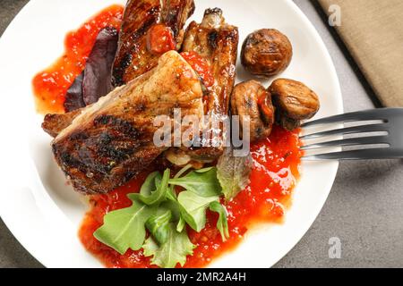 Délicieuses côtes grillées servies sur une table grise, vue du dessus Banque D'Images