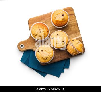 Muffins à la vanille sur planche à découper isolés sur fond blanc. Banque D'Images