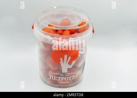 Larnaca, Chypre - 05 août 2021: Studio de petites tomates cerises dans un emballage de bocal en plastique à proximité du blanc. Banque D'Images