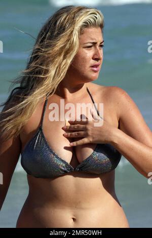 EXCLUSIF !! Playboy Model, Josie Goldberg, donne un bikini argenté étincelant pendant une journée sur la plage. Josie, qui est actuellement en ville pour voir un médecin spécialiste au sujet de sa cicatrice keloïde, a également pris un plongeon dans l'océan après lequel son bandaid s'est délogé pour révéler la cicatrice. Miami Beach, Floride. 1/2/11. . Banque D'Images