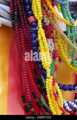 Jeu de perles de verre colorées accrochées devant un matériau coloré. Image verticale Banque D'Images