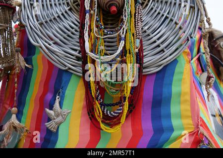 Jeu de perles de verre colorées accrochées devant un panier et un matériau coloré. Banque D'Images