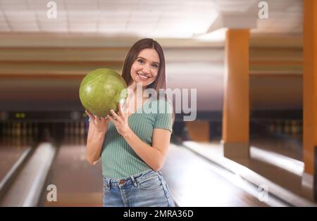 Jeune femme avec ballon Dans bowling club Banque D'Images