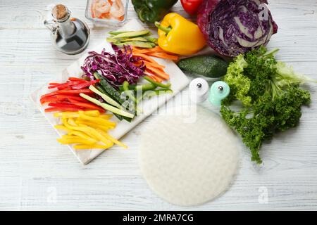 Sécher le papier de riz et les ingrédients sur une table en bois blanc, à plat Banque D'Images